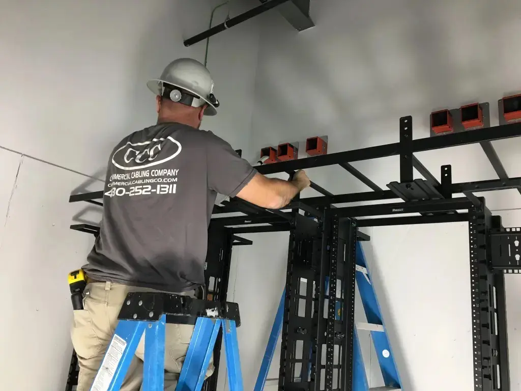 A man working on some scaffolding in the corner of a room.