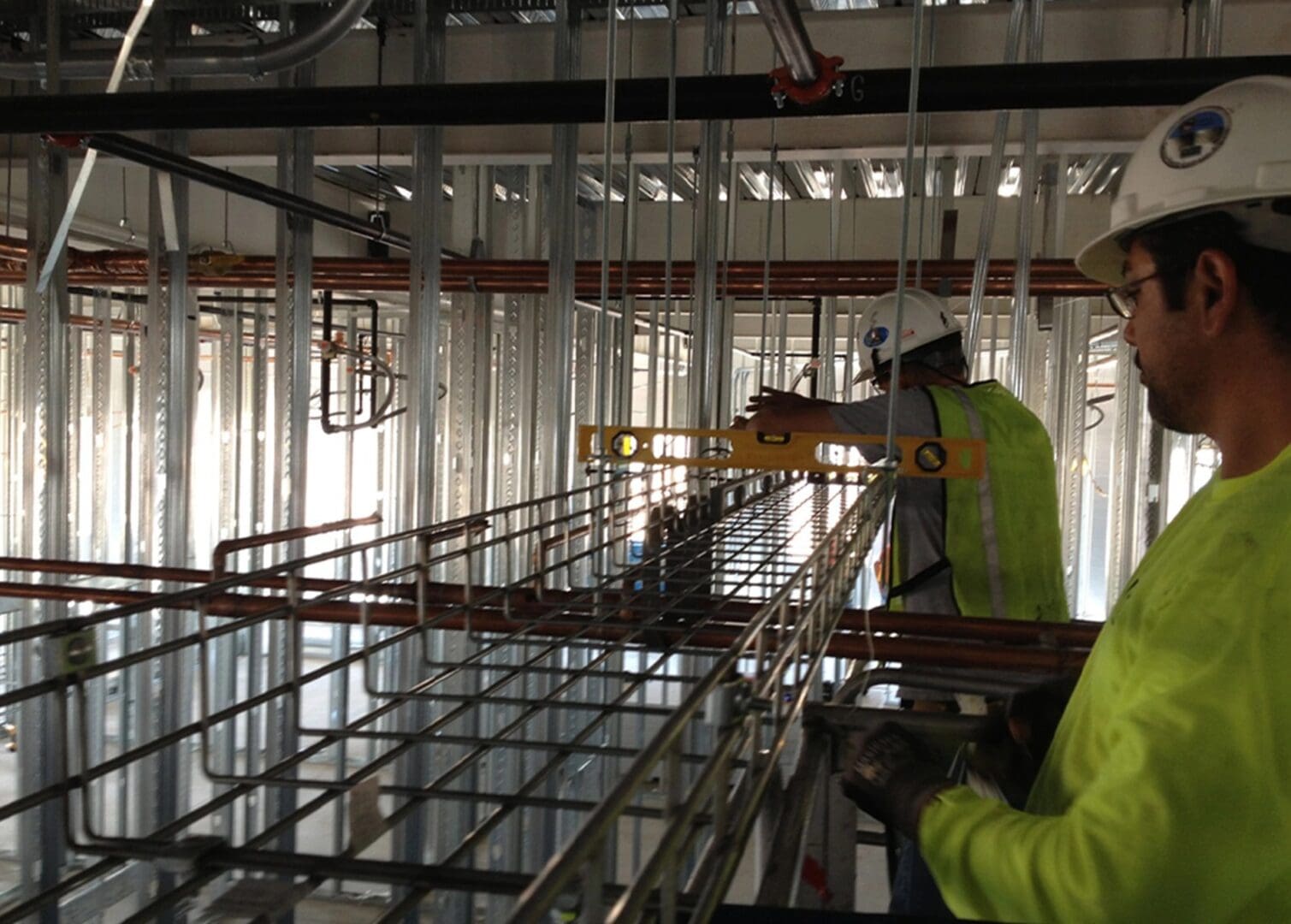 A construction worker is working on the ceiling.