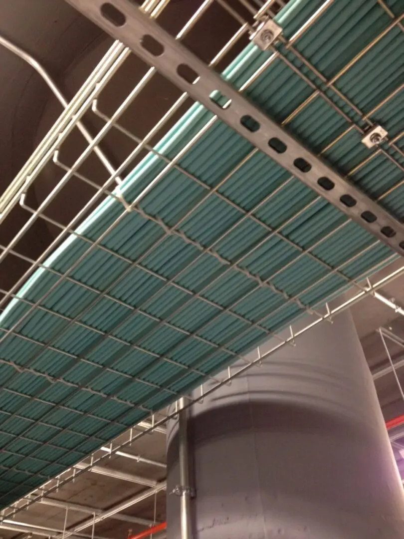 A ceiling with blue plastic covering and metal bars.