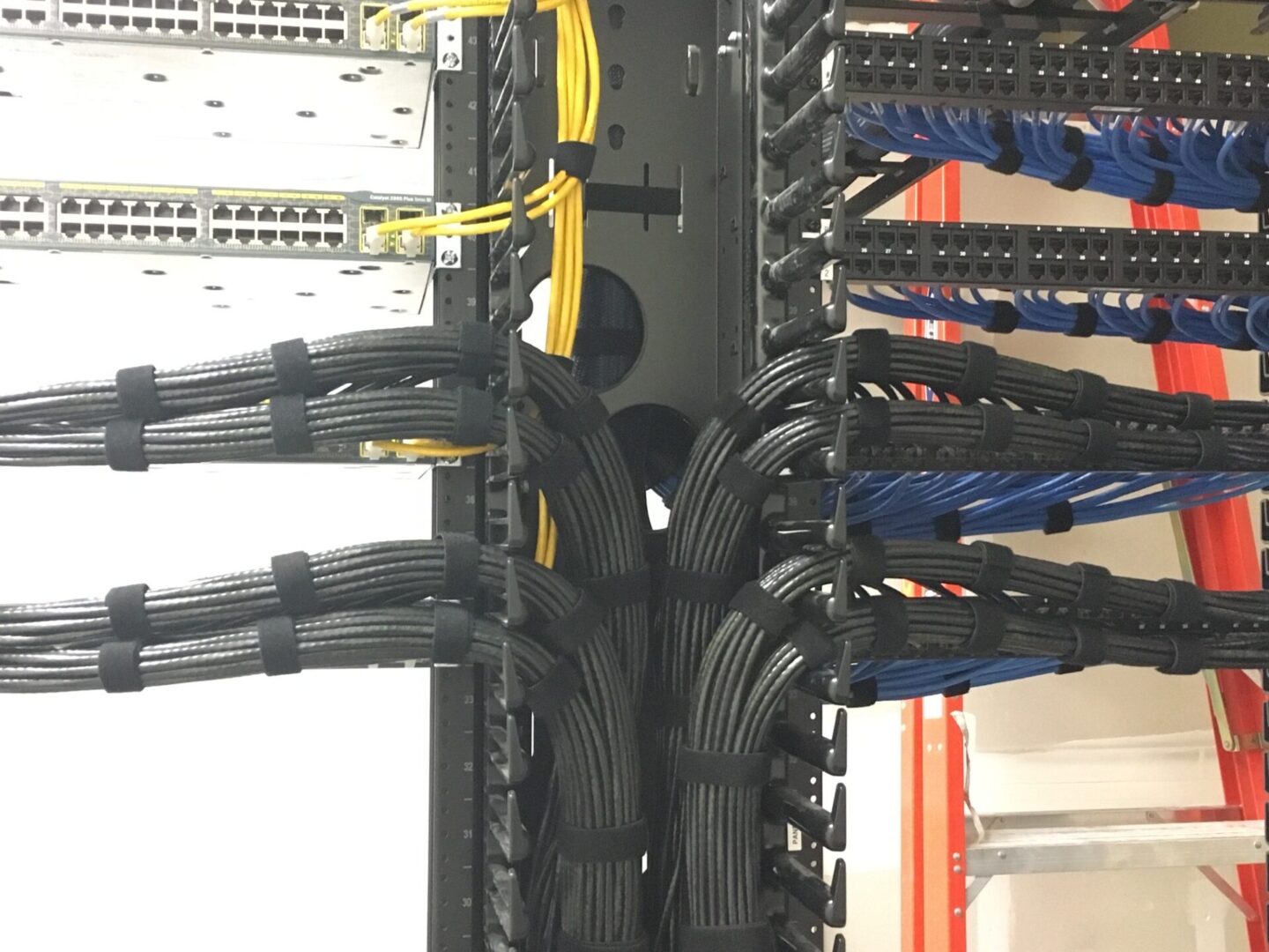 A bunch of wires hanging from the side of a rack.