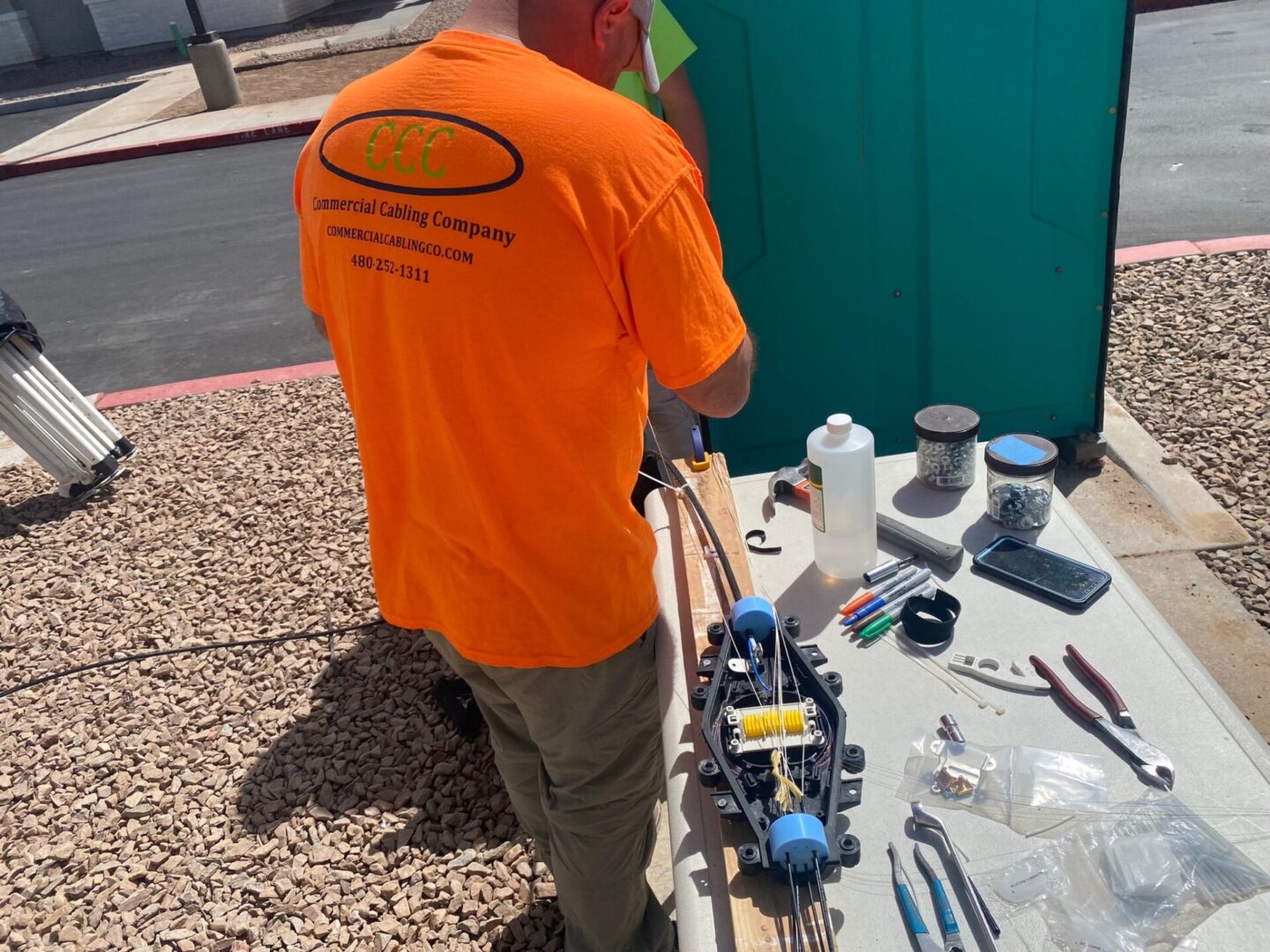 A man in an orange shirt is painting the wall.