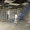 A man in white shirt and pants standing inside of room.